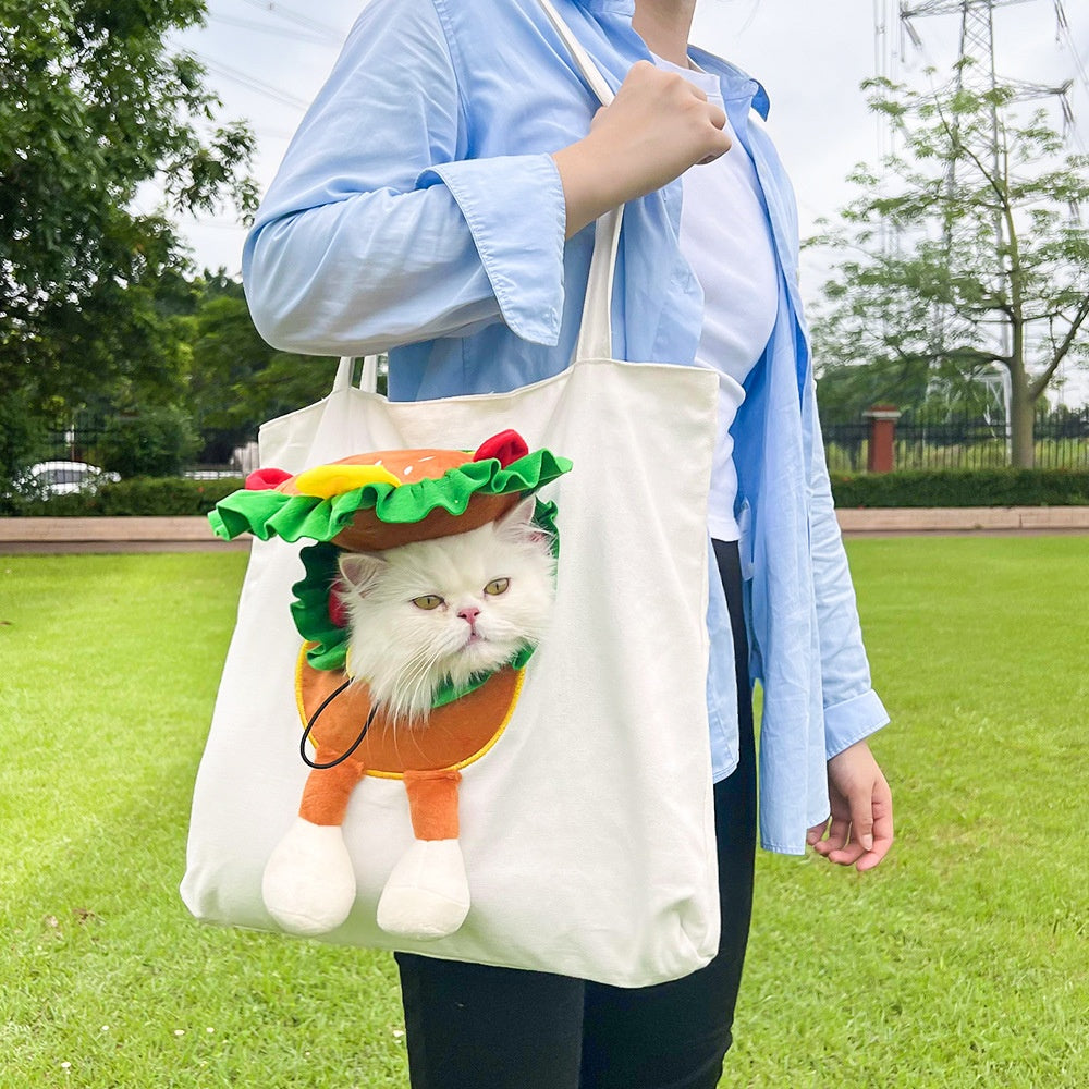 Person holding a tote bag with a cat design of a taco outdoors.