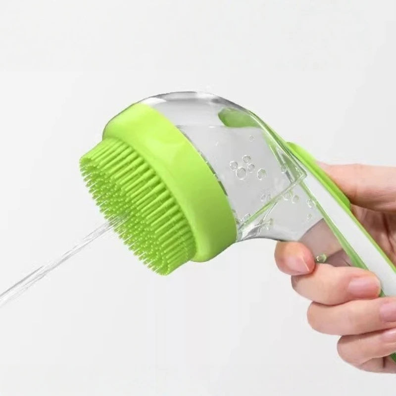 Hand holding a green and clear cleaning brush with water being sprayed.