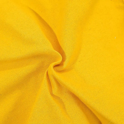 A close-up of bright yellow fabric with a visible woven texture and soft folds gathered toward the center.