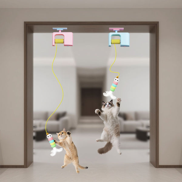Two cats playing with a hanging toy in a room.